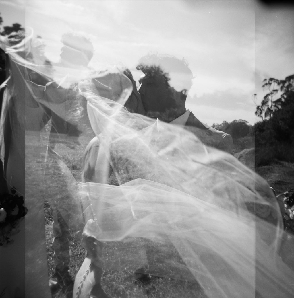 Bride and groom kissing, captured by Kadi Tobin, a Documentary and Candid wedding photographer in the central coast
